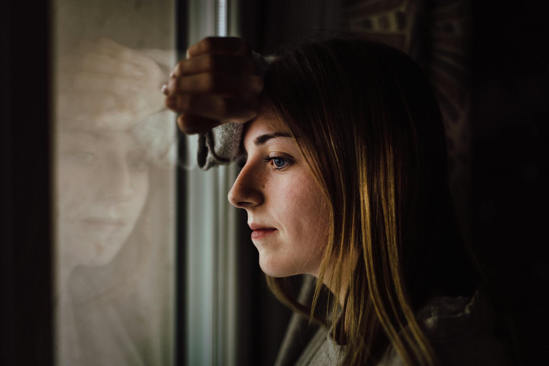 woman leaning on glass window