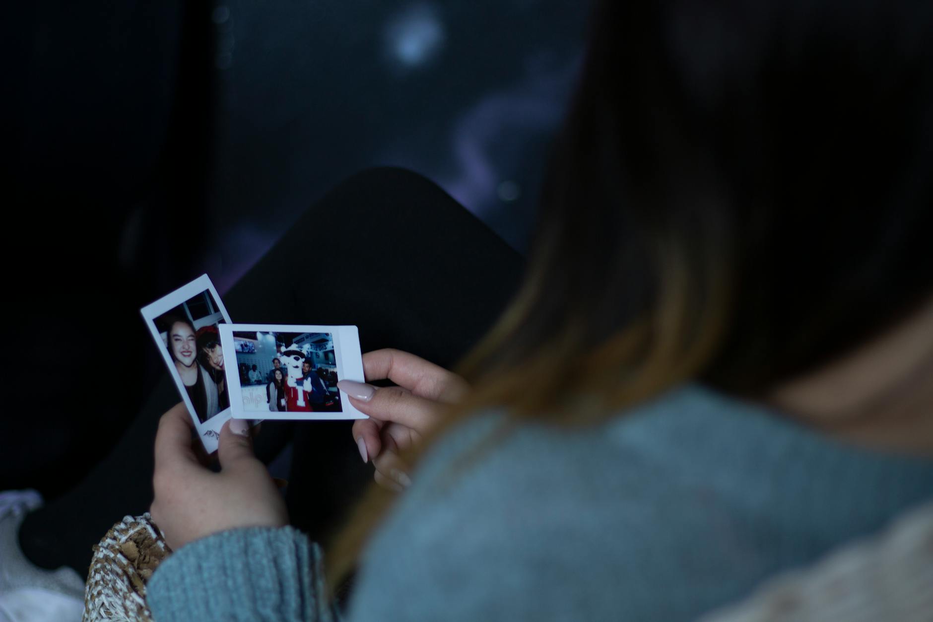 woman holding two photos